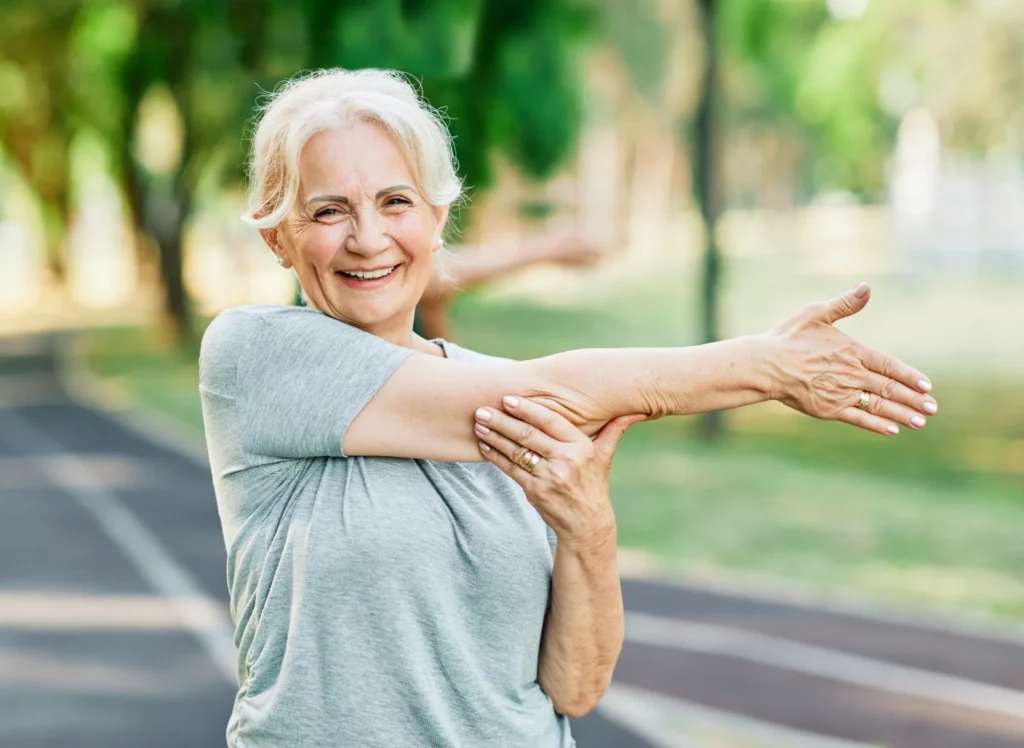 happy senior woman stretching outdoors in park 2026 01 09 10 12 58 utc